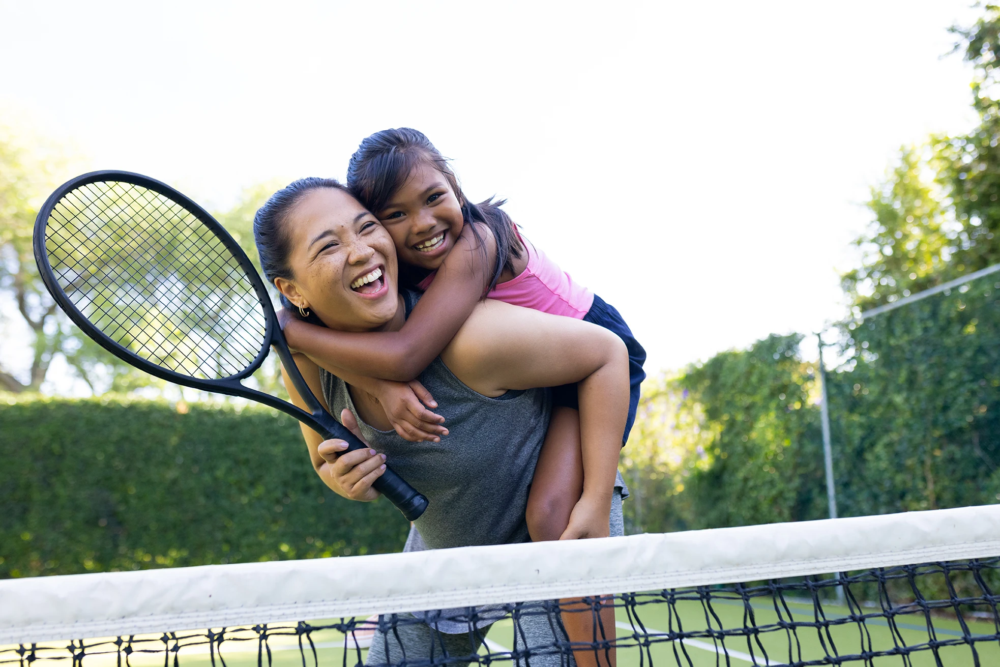 Outdoors biracial mother daughter smiling with tennis rackets tennis court 1