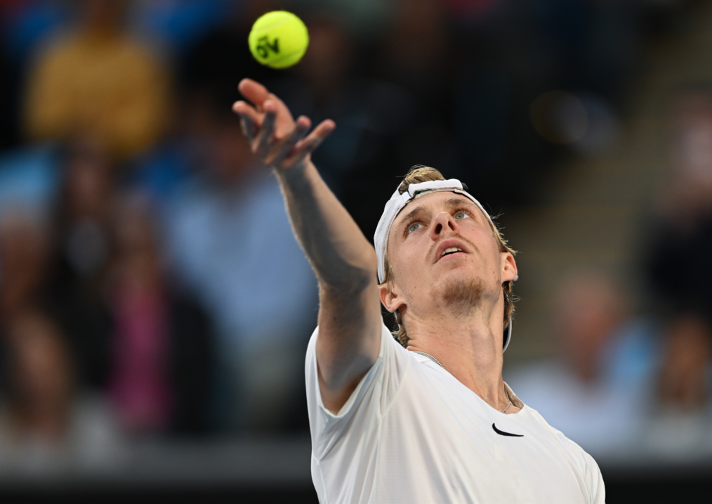 Denis Shapovalov tosses the ball up to serve.