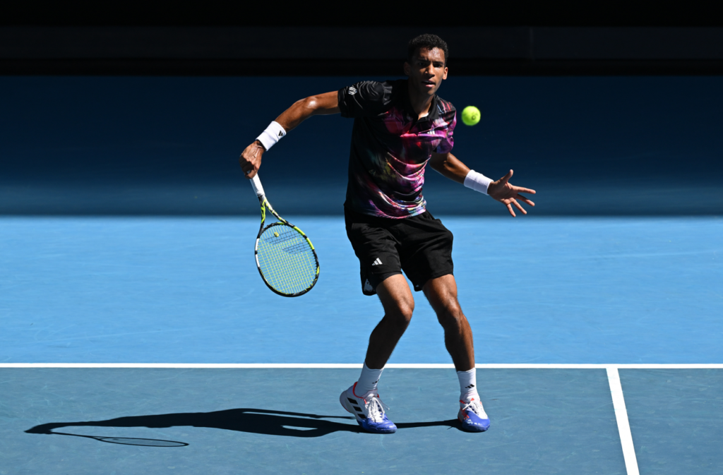 Felix Auger-Aliassime follows through on a slice backhand.