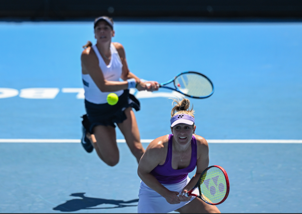 Giuliana Olmos hits a forehand from behind Gabriela Dabrowski.