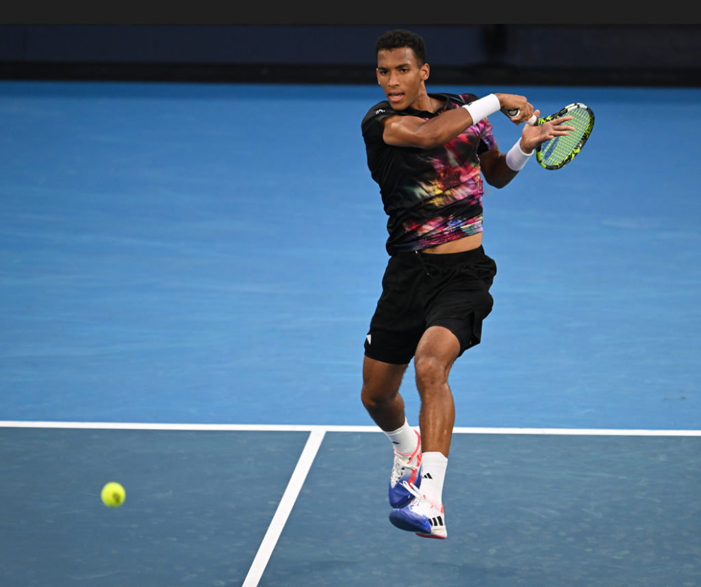 Felix Auger-Aliassime follows through on a forehand.