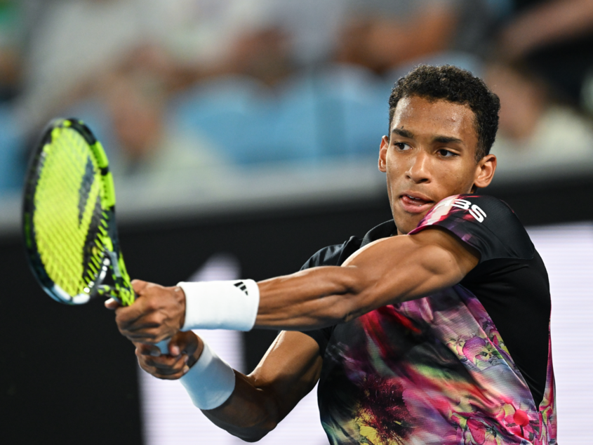 Felix Auger-Aliassime follows through on a backhand.